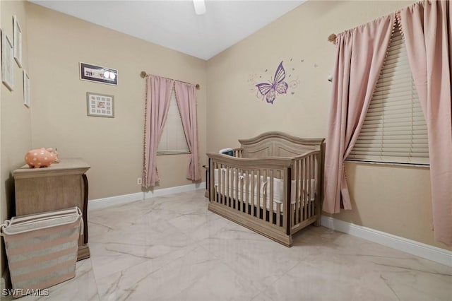 bedroom featuring a crib and ceiling fan