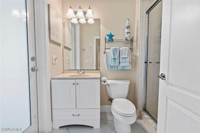 bathroom with vanity, toilet, and a shower with shower door