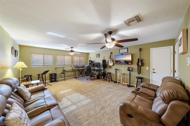 living room featuring ceiling fan, light colored carpet, and a textured ceiling