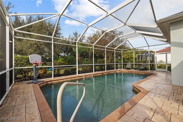 view of pool with glass enclosure and a patio area