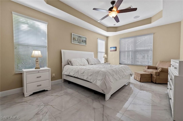 bedroom featuring ceiling fan and a tray ceiling