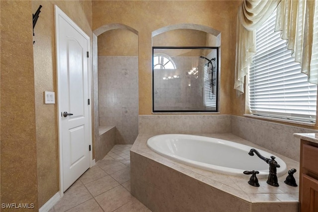 bathroom featuring tile patterned floors, vanity, plus walk in shower, and plenty of natural light