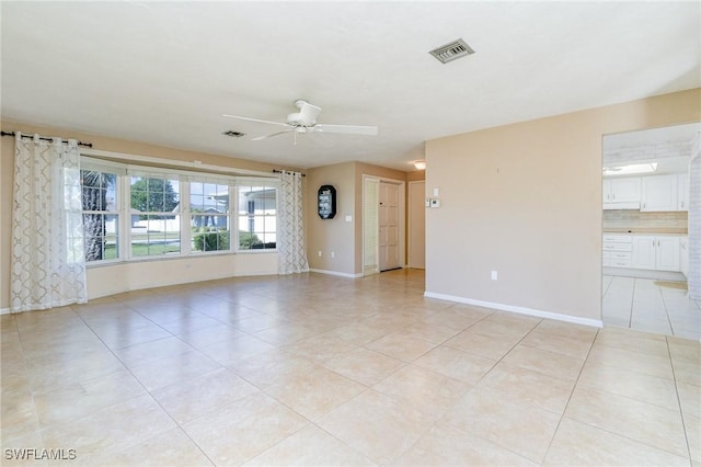 tiled spare room featuring ceiling fan