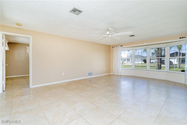 tiled spare room featuring ceiling fan