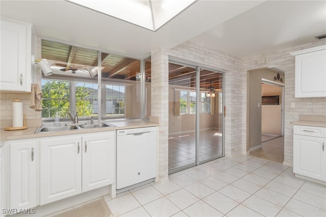 kitchen with white cabinets, white dishwasher, a healthy amount of sunlight, and sink