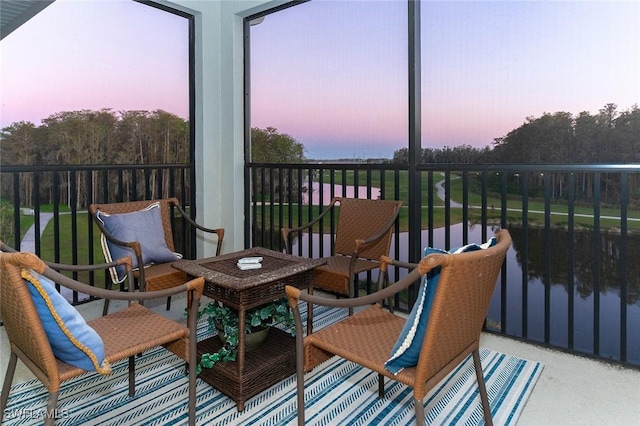 sunroom / solarium featuring a water view