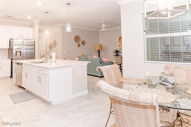 kitchen featuring ornamental molding, stainless steel appliances, sink, white cabinets, and hanging light fixtures