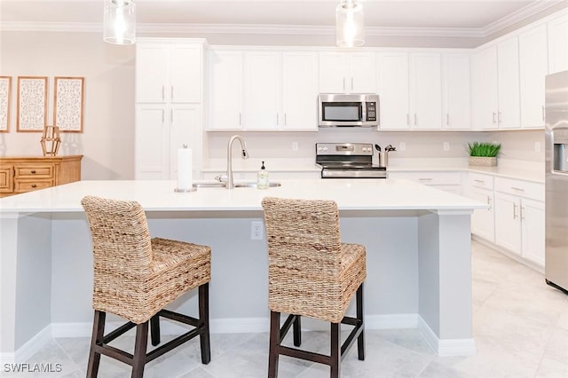 kitchen featuring white cabinets, a kitchen breakfast bar, a center island with sink, hanging light fixtures, and stainless steel appliances