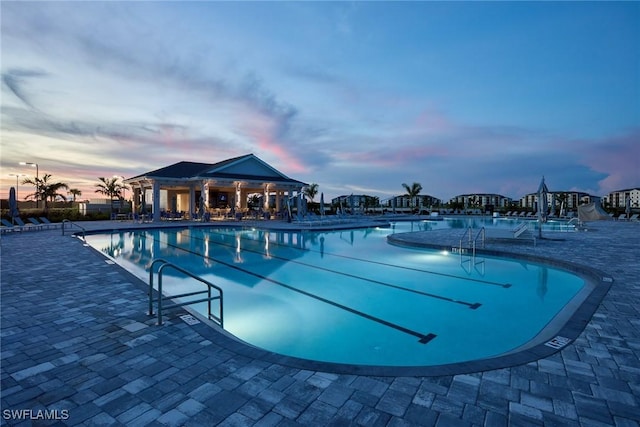 pool at dusk with a patio