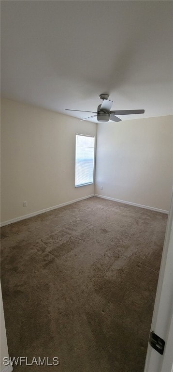 empty room with ceiling fan and dark carpet