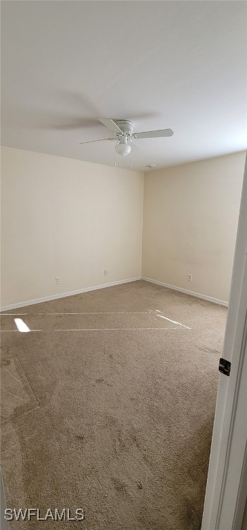 spare room with ceiling fan and carpet