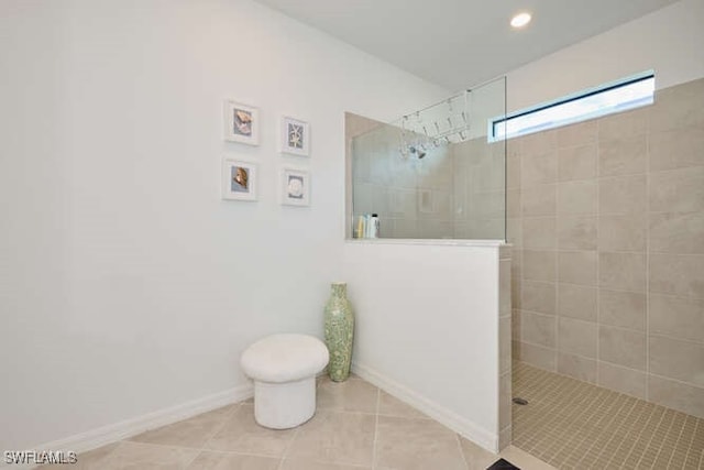 bathroom with tile patterned flooring and tiled shower