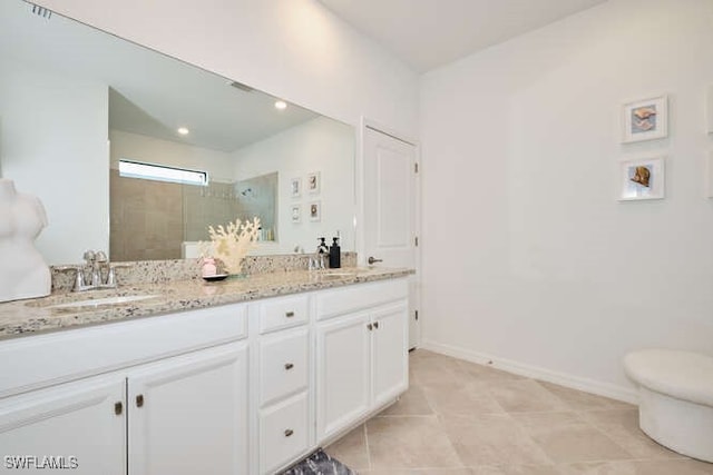 bathroom with a tile shower, tile patterned flooring, vanity, and toilet