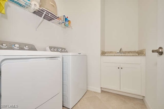 laundry area featuring sink, light tile patterned floors, and independent washer and dryer