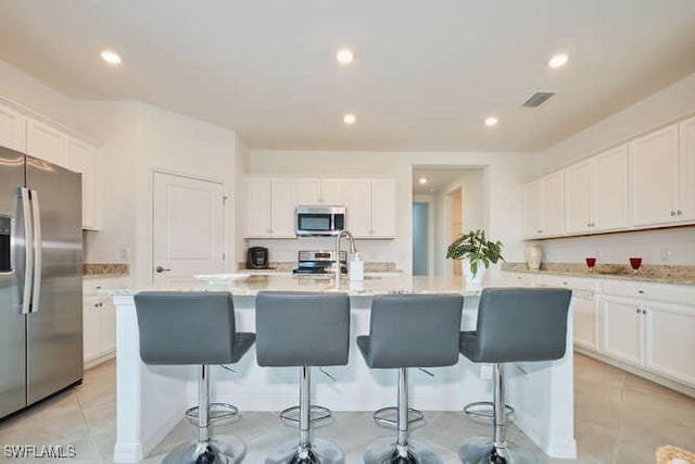 3426 Menores Way, Fort Myers, FL 33905 - kitchen featuring stainless steel appliances, white cabinets, recessed lighting, and a center island with sink