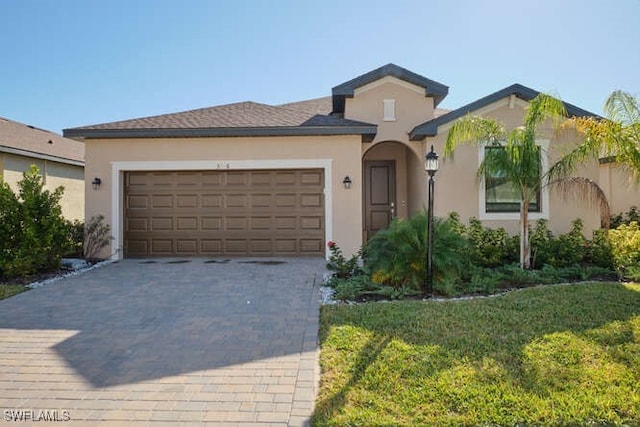 3426 Menores Way, Fort Myers, FL 33905 - view of front facade with driveway, a garage, stucco siding, and a front yard