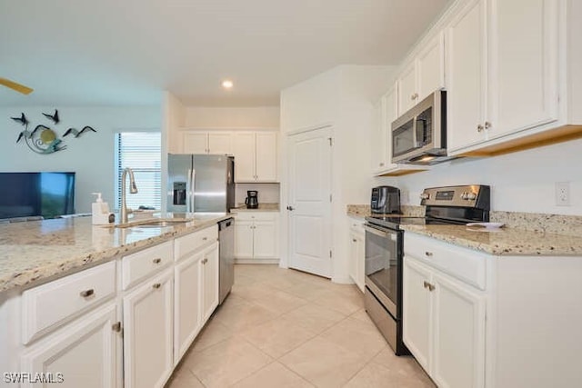 3426 Menores Way, Fort Myers, FL 33905 - kitchen featuring appliances with stainless steel finishes, white cabinetry, light tile patterned floors, light stone countertops, and recessed lighting
