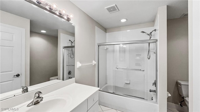 full bathroom featuring tile patterned flooring, vanity, bath / shower combo with glass door, and toilet