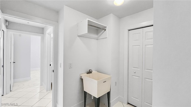 clothes washing area with light tile patterned floors