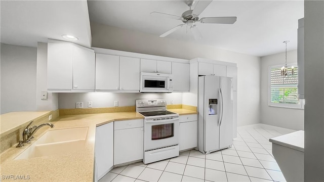 kitchen featuring pendant lighting, white appliances, white cabinets, ceiling fan with notable chandelier, and sink