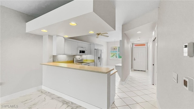 kitchen with kitchen peninsula, ceiling fan, white cabinets, and stainless steel appliances