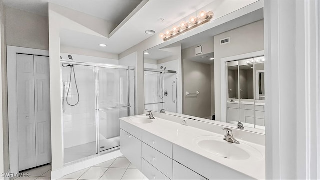 bathroom with tile patterned flooring, vanity, and walk in shower