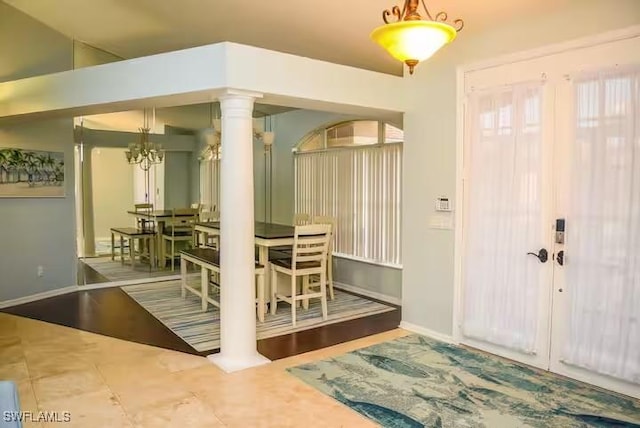 dining room with a notable chandelier, wood-type flooring, and decorative columns