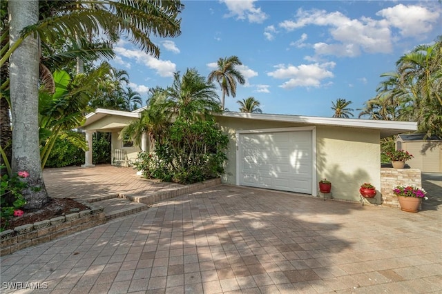 view of front facade with decorative driveway and stucco siding