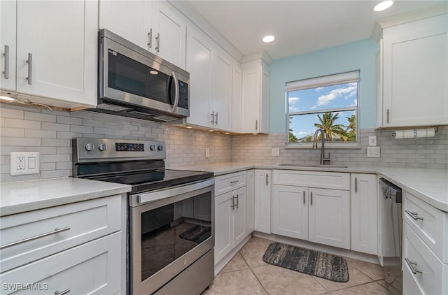 kitchen featuring tasteful backsplash, white cabinetry, sink, and appliances with stainless steel finishes