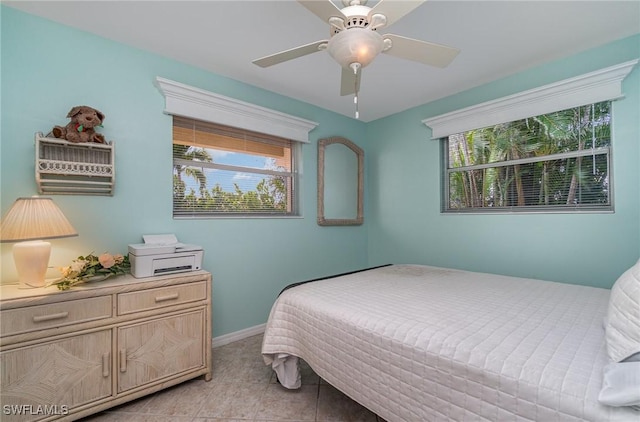 bedroom featuring multiple windows, ceiling fan, and light tile patterned floors