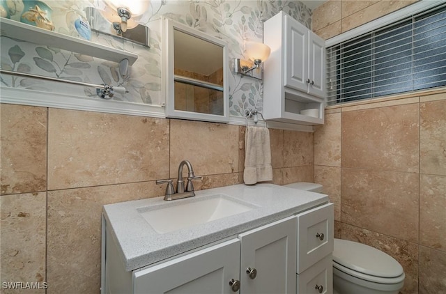 bathroom with backsplash, vanity, toilet, and tile walls