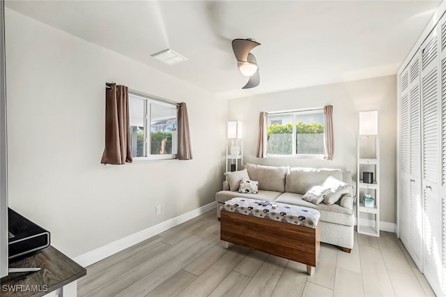 living room featuring ceiling fan and light hardwood / wood-style floors