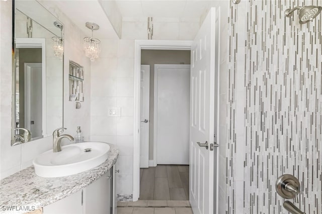 bathroom featuring vanity, tile walls, and a notable chandelier