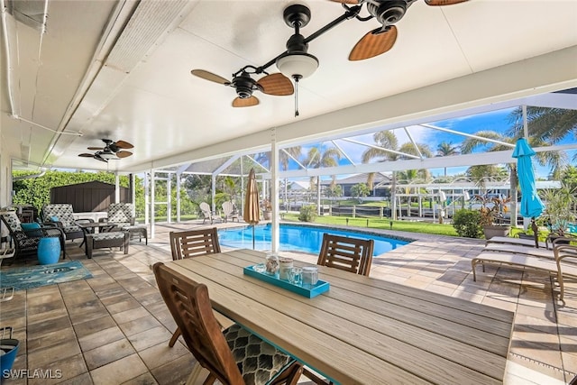 sunroom featuring ceiling fan and a swimming pool