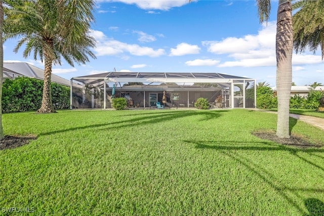 rear view of house featuring glass enclosure and a yard