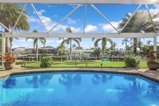 view of pool with glass enclosure and a yard