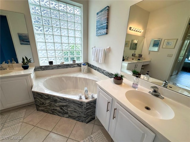 bathroom featuring tile patterned floors, vanity, and a relaxing tiled tub