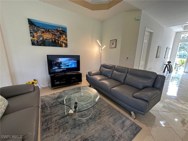 tiled living room featuring ornamental molding and a tray ceiling