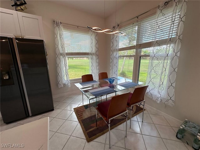 tiled dining space featuring a notable chandelier and plenty of natural light