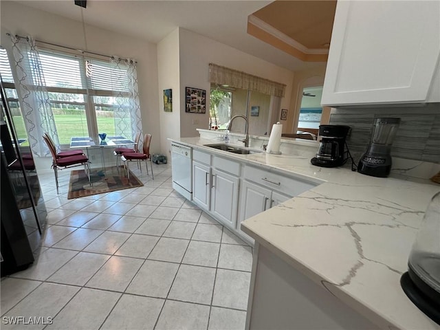 kitchen with dishwasher, sink, decorative light fixtures, a tray ceiling, and white cabinets