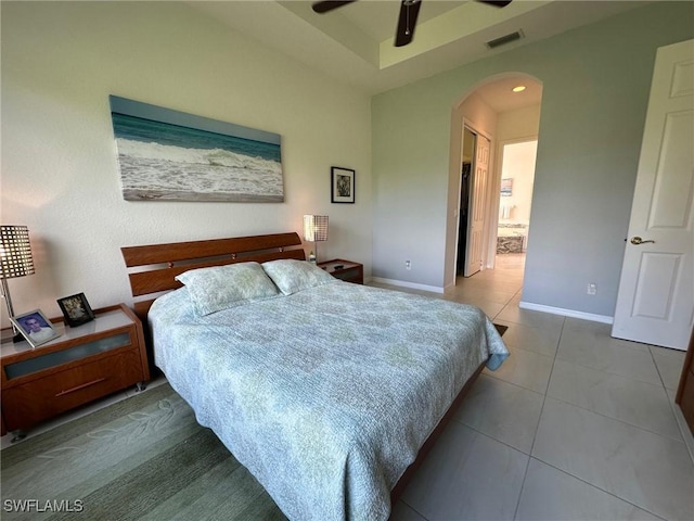 tiled bedroom with ensuite bath and ceiling fan