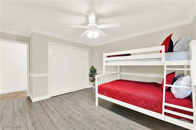 bedroom with wood-type flooring, a closet, ceiling fan, and crown molding