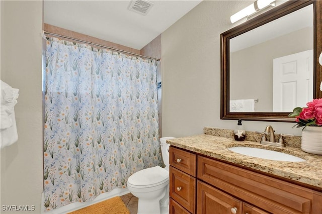 bathroom featuring tile patterned floors, curtained shower, vanity, and toilet