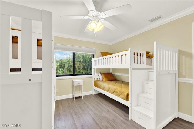 unfurnished bedroom featuring ceiling fan, ornamental molding, and hardwood / wood-style flooring