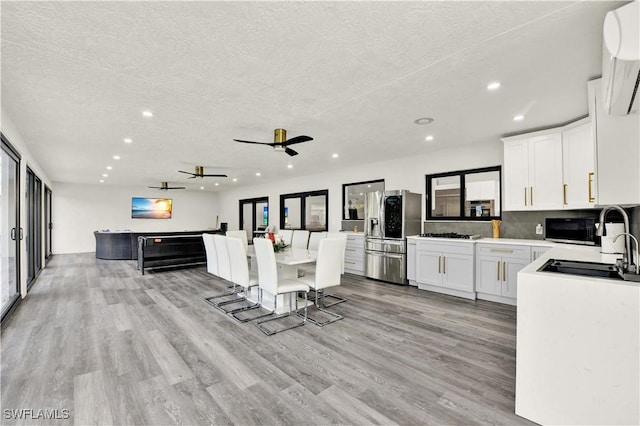 kitchen with white cabinets, stainless steel fridge with ice dispenser, a textured ceiling, and ceiling fan