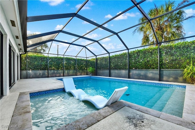 view of swimming pool featuring a patio and glass enclosure