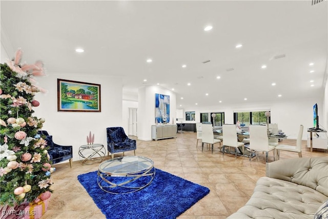 living room with light tile patterned floors and crown molding