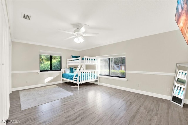 unfurnished bedroom with hardwood / wood-style floors, ceiling fan, and crown molding