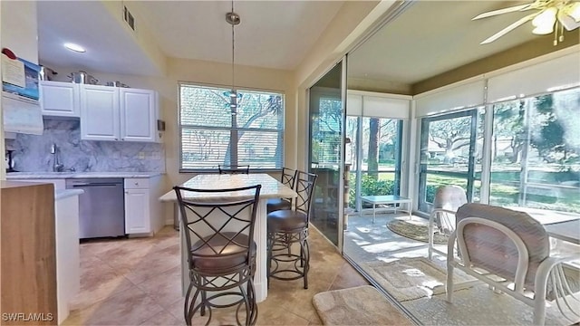 kitchen with white cabinetry, dishwasher, pendant lighting, and plenty of natural light