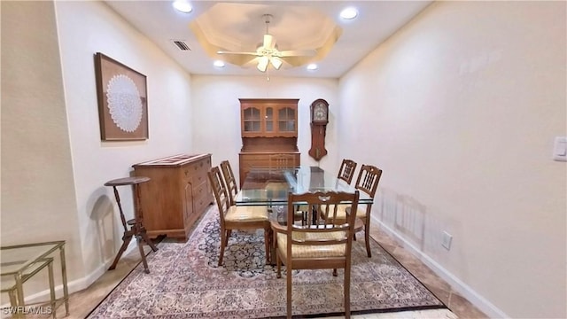 dining area featuring a raised ceiling and ceiling fan